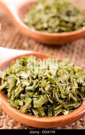 La ciboulette en tranches dans la cuillère en bois d'épices Banque D'Images