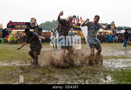 Londres, Royaume-Uni. Août 24, 2013. Un groupe de festivaliers glisser dans la boue au cours de la première journée du sud ouest quatre music festival à Clapham Common, London. Crédit : Robert Fisher/Alamy Live News Banque D'Images