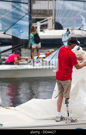 Un amputé marin prépare les voiles d'un canot de course de sonar avant course commence pour une mobilité voilier régate dans NEWPORT RI Banque D'Images