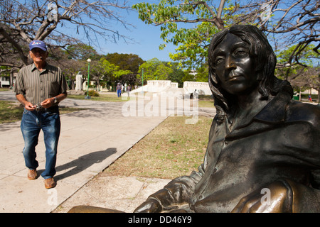 Une statue de John Lennon assis sur un banc sans lunettes dans le parc John Lennon à La Havane, capitale de Cuba Banque D'Images