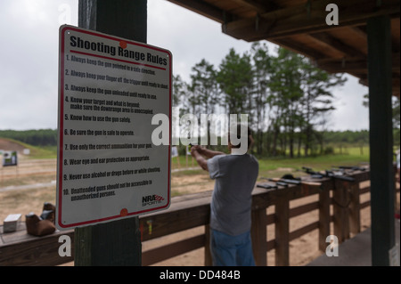 Man son tir au pistolet de tir dans la forêt nationale d'Ocala, États-Unis avec la gamme règles affichées l'avant-plan Banque D'Images