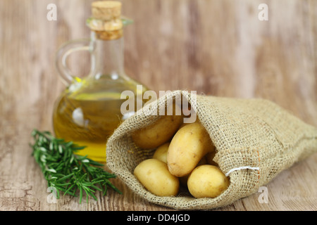 Pommes de terre en sac de jute, du romarin frais et d'huile d'olive with copy space Banque D'Images