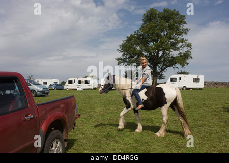 Un jeune voyageur fait l'essai d'une nouvelle à l'ancien poney Priddy annuel (moutons et chevaux) juste à Somerset, Angleterre. Banque D'Images