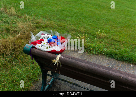 Fleurs Memorial on park bench Banque D'Images