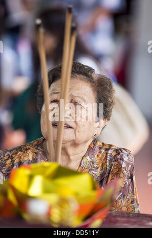 Le 26 août 2013 - Bangkok, Thaïlande - une femme prie devant offrant du riz à la Fondation Poh Teck Tung pendant Mois Esprit affamé à Bangkok. Poh Teck Tung gère des hôpitaux et des écoles et fournit une aide aux pauvres en Thaïlande. Le septième mois lunaire (Août - Septembre 2013), c'est quand la communauté chinoise croit que le Hell's Gate s'ouvre pour permettre aux esprits de se déplacer librement dans le monde des humains pour un mois. De nombreux ménages et temples organisera des cérémonies de prière tout au long du mois-long esprit affamé Festival (Phor Thor) pour apaiser les esprits. (Crédit Image : © Jack Kurtz/ZUMAPRESS.com) Banque D'Images