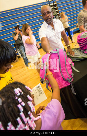 Darius Rucker de Hootie et les distribuer aux enfants sacs à dos Blowfish durant la Hootie Roundup de chez nous le 24 août 2013 à Charleston, Caroline du Sud. La rafle distribue des fournitures scolaires, des soins dentaires et ophtalmologiques et les coupes de cheveux des étudiants défavorisés dans la région de Charleston Comté. Banque D'Images