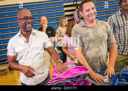 Darius Rucker, gauche, et Dean Felber de Hootie et les distribuer aux enfants sacs à dos Blowfish durant la Hootie Roundup de chez nous le 24 août 2013 à Charleston, Caroline du Sud. La rafle distribue des fournitures scolaires, des soins dentaires et ophtalmologiques et les coupes de cheveux des étudiants défavorisés dans la région de Charleston Comté. Banque D'Images