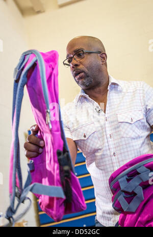 Darius Rucker de Hootie et les distribuer aux enfants sacs à dos Blowfish durant la Hootie Roundup de chez nous le 24 août 2013 à Charleston, Caroline du Sud. La rafle distribue des fournitures scolaires, des soins dentaires et ophtalmologiques et les coupes de cheveux des étudiants défavorisés dans la région de Charleston Comté. Banque D'Images