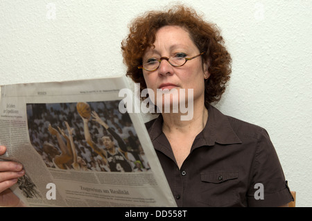 Femme lisant un exemplaire du journal allemand Suddeutsche Zeitung Banque D'Images