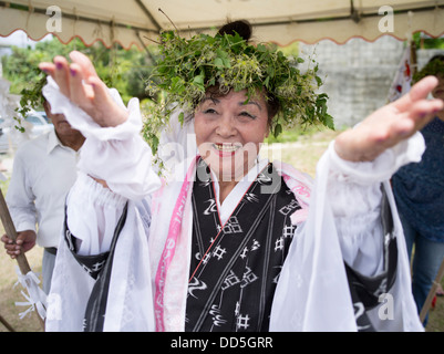 Émiko Toguchi Ayako (79) dirige la prière au Unjami Festival le Kouri Island, Okinawa Banque D'Images