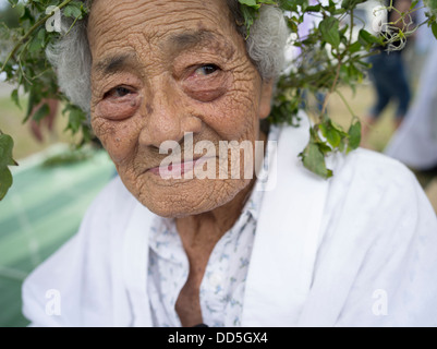 96 ans Kaneshi Fusae wearing wreath d botanzuru Unjami ryukyu au Festival sur Kouri Island, Okinawa Banque D'Images