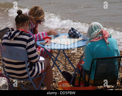 Trois femmes jouant au Scrabble à la plage, Lymington, Dorset, UK 2013 Banque D'Images