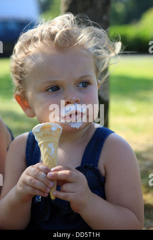 Fillette de deux ans avec de la glace autour de sa bouche sur une chaude journée d'été Banque D'Images