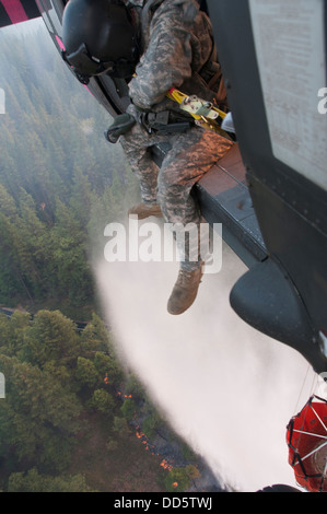 Le Sgt. Chris Boni, chef d'équipage de la Garde nationale de Californie, 1-140ème bataillon de l'Aviation (Air Assault) sur la base de formation conjointe de Los Alamitos (JFTB), les rejets de l'eau sur la tête arrosant le rim fire ci-dessous près de Yosemite National Park. Le Sapin Rim Banque D'Images