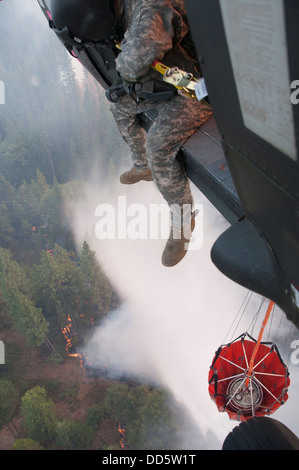 Le Sgt. Chris Boni, chef d'équipage de la Garde nationale de Californie, 1-140ème bataillon de l'Aviation (Air Assault) sur la base de formation conjointe de Los Alamitos (JFTB), les rejets de l'eau sur la tête arrosant le rim fire ci-dessous près de Yosemite National Park. Le Sapin Rim Banque D'Images