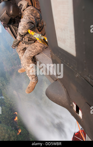 Le Sgt. Chris Boni, chef d'équipage de la Garde nationale de Californie, 1-140ème bataillon de l'Aviation (Air Assault) sur la base de formation conjointe de Los Alamitos (JFTB), les rejets de l'eau sur la tête arrosant le rim fire ci-dessous près de Yosemite National Park. Le Sapin Rim Banque D'Images