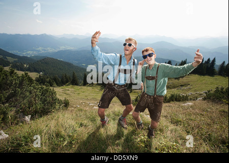 Allemagne, Bavière, deux garçons en costume traditionnel de jouer dans les montagnes Banque D'Images