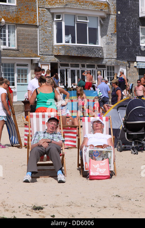 St Ives Cornwall vieux couple vous détendre dans des chaises longues dans le soleil de l'été sur la plage d'août 2013 Banque D'Images