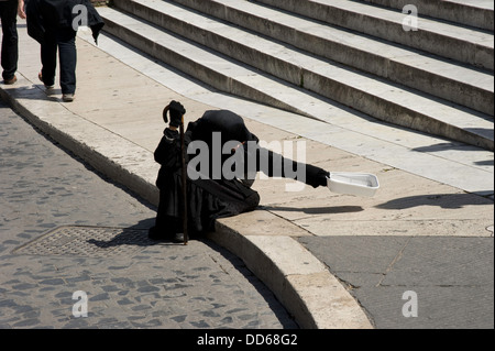 Personnes âgées handicapé femme vêtue de noir mendiant dans la rue à Rome, Italie, Europe. Banque D'Images