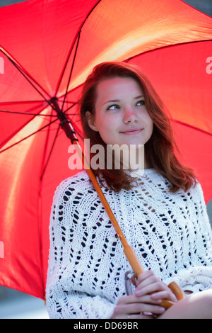 Heureux jeune femme avec parapluie ouvert à portée de main Banque D'Images