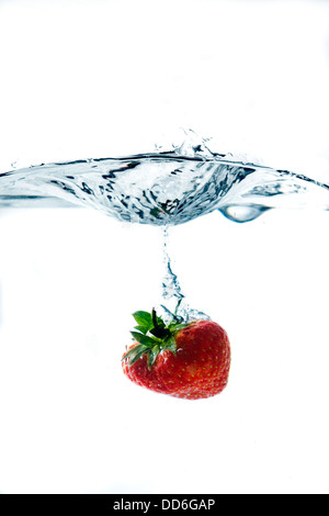 Tomber dans l'eau de fraise Banque D'Images