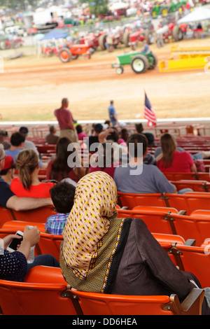 Une femme musulmane observe un tracteur tirant contest au North Carolina State Fairgrounds, Raleigh (Caroline du Nord, USA Banque D'Images