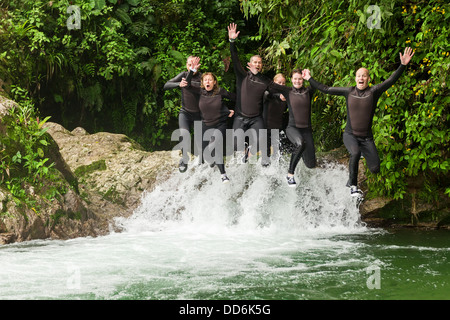 Groupe de six personnes trois paires Jump Dans le même temps dans une chute d'expédition Canyoning Banque D'Images