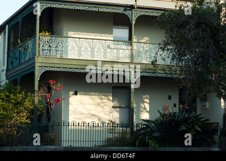 Une terrasse victorienne traditionnelle Sydney maison avec véranda et balcon, laçage sur la ferronnerie photographié en fin d'après-midi. Banque D'Images