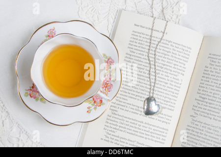 Une tasse de thé situé au-dessus d'un livre/roman romantique Banque D'Images