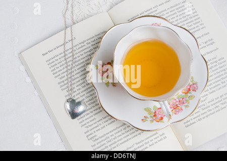 Une tasse de thé situé au-dessus d'un livre/roman romantique Banque D'Images