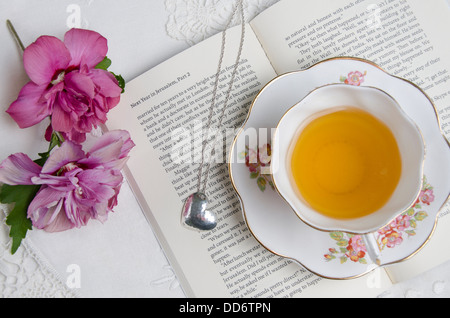 Une tasse de thé situé au-dessus d'un livre/roman romantique Banque D'Images