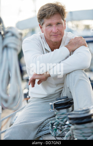 Caucasian man sitting on voilier Banque D'Images