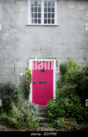 Une porte rose à un vieux cottage Banque D'Images