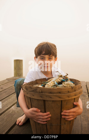 Caucasian boy holding panier de crabes Banque D'Images