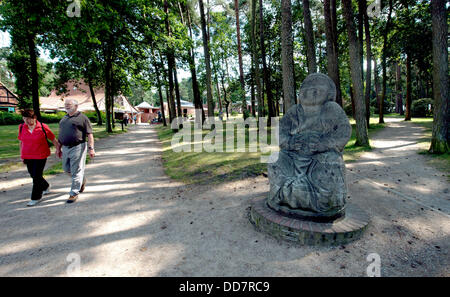 Les gens passent devant la statue d'un bouddha souriant ''Bronze' dans l'Humour de Worpswede, Allemagne, 16 août 2013. Le monument en pierre a été conçu par Bernhard Hoetger en 1914. Photo : Carmen Jaspersen Banque D'Images