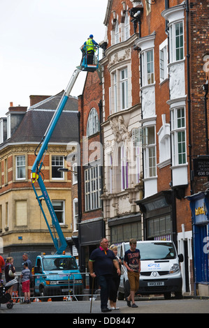 Les entrepreneurs sur la plate-forme d'accès haute sécurité faire un bâtiment après avoir été endommagé par la foudre dans la ville de York England UK Banque D'Images