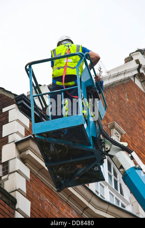 Les entrepreneurs sur la plate-forme d'accès haute sécurité faire un bâtiment après avoir été endommagé par la foudre dans la ville de York England UK Banque D'Images