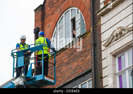 Les entrepreneurs sur la plate-forme d'accès haute sécurité faire un bâtiment après avoir été endommagé par la foudre dans la ville de York England UK Banque D'Images