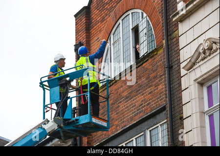 Les entrepreneurs sur la plate-forme d'accès haute sécurité faire un bâtiment après avoir été endommagé par la foudre dans la ville de York England UK Banque D'Images