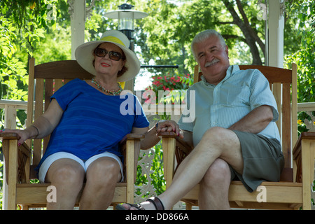 Couple de retraités se reposant dans le gazebo tout en tenant par la main Banque D'Images