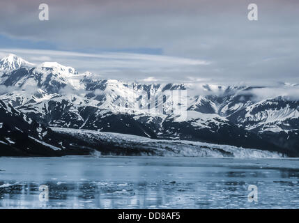 11 juillet 2000 - La baie de Yakutat, Alaska, Etats-Unis - Le Glacier Hubbard à la tête de la baie de Yakutat, Alaska. Le robuste sur les sommets enneigés des montagnes Saint Elias dans Wrangell-St. Elias National Park, lieu derrière ce plus grand glacier tidewater sur le continent nord-américain, désigné site du patrimoine mondial des Nations Unies. L'extension de 76 mi (122 km) du Mt. Logan au Yukon, son visage est plus de 6 miles (9,6 km) et à 600 ft (180 m) de haut (350 ft exposé au-dessus de la flottaison et 250 ft ci-dessous). Plaques de glace d'Hubbard, l'un des plus actifs de l'Alaska le vêlage des glaciers, peut être vu dans la baie. (Crédit Image : © Arnold Drapk Banque D'Images