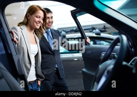 Dealer montrant un nouveau modèle de voiture à l'acheteur potentiel Banque D'Images