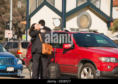 Hispanic couple hugging in parking lot Banque D'Images