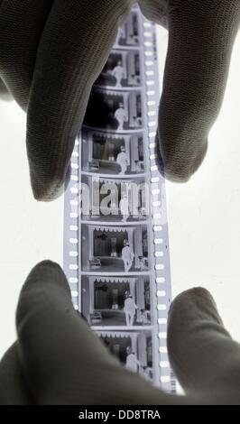 Membre du personnel Miriam Piorno examine une bobine de film du film "Der Himmel auf Erden" (lit. Le paradis sur terre) à partir de 1935, dans le département de la restauration de films et de la conservation à la German Federal Film Archive à Berlin, Allemagne, 12 août 2013. Le directeur du département pour la restauration et la conservation du film s'inquiète de l'état de désolation de certains des dépôts de films qui sont répartis dans des installations différentes à différents endroits. Les négociations sont en cours depuis des années au sujet d'un nouveau film de l'installation centrale pour la conservation et l'archivage dans Berlin, près de Berlin. Photo Banque D'Images