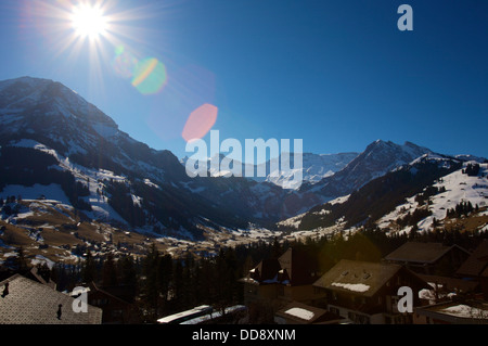 La solarisation et appareil photo sur flare enneigés des montagnes suisses avec ciel bleu Banque D'Images