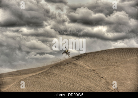 Un motard saleté saute une dune dans le désert de dunes de sable, le 26 mai 2013 situé dans le sud et le centre de la vallée de dunes de sable, de l'Oregon. Les dunes sont composées en grande partie de cendres et de pierres ponces qui a soufflé dans la région il y a 7 000 ans lorsque Mt. Éruption de Mazama, formant le lac du cratère. Banque D'Images