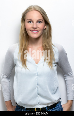 Portrait of young smiling woman in front of white background Banque D'Images