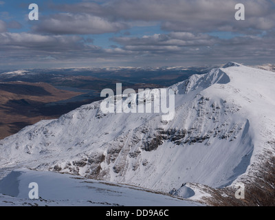 Vue vers le sommet de la montagne enneigée dans Mialach Spidean Glenquoich Forest avec le Loch Loyne dans la distance, l'Ecosse UK Banque D'Images