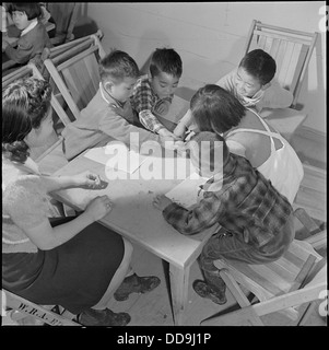 Les enfants dans une classe préscolaire au Jerome Relocation Center, Denson, Arkansas, reflètent la dynamique éducative et sociale pendant la période d'internement japonais-américain. Banque D'Images