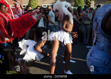 Interprètes de la danse du carnaval de Notting Hill à bum bum portant des costumes blancs à la joie des spectateurs. Banque D'Images